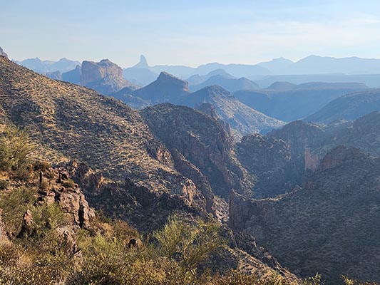 Peaks in abstract shape and large fins of rock rise above a narrow canyon