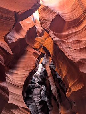 A narrow red rock canyon has been carved into otherworldly shapes by wind and rain